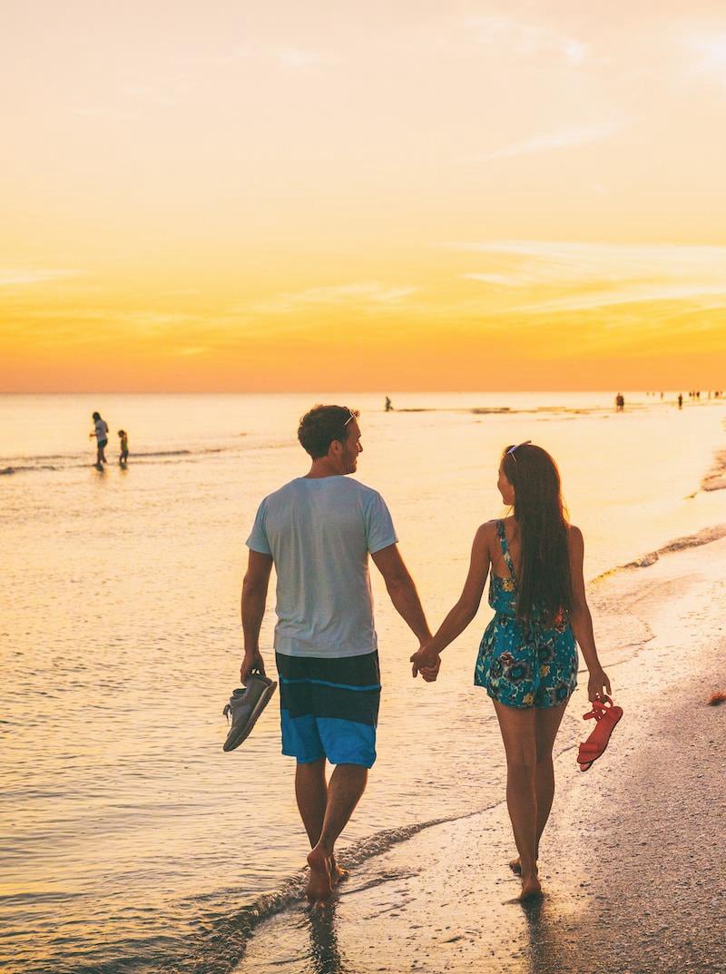 Una pareja camina por la playa.